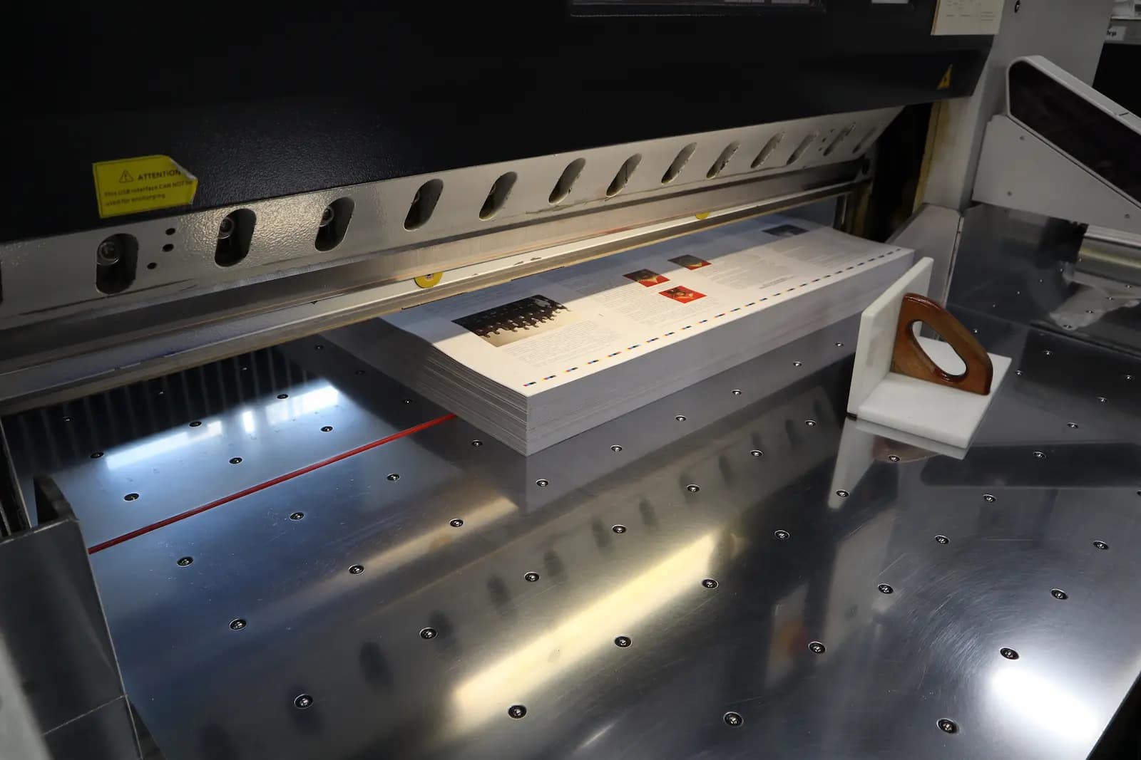 Печатные листы на резке в бумагорезательной машине